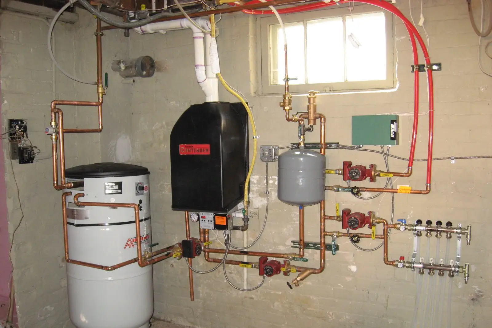 Wall-hung condensing boiler with copper piping and circulator pumps in a brick basement